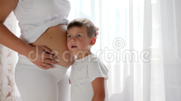 好奇的小儿子听着怀孕的母亲说她的肚子很大视频的预览图
