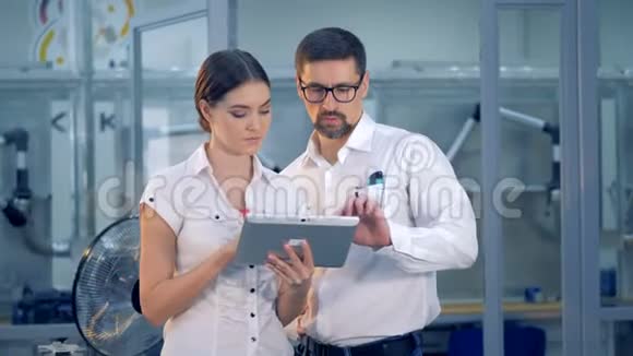 男工程师正在给一个拿着平板电脑的女工程师指示视频的预览图