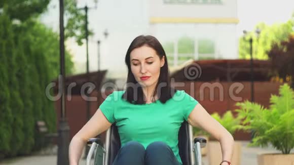 残疾残疾的年轻漂亮女孩坐轮椅看着摄像机视频的预览图