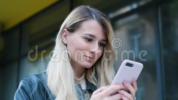 女人在城里散步用智能手机漂亮的时髦女郎学生女孩在户外智能手机上发短信和使用应用程序视频的预览图