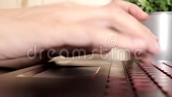 女性手在触摸板上滚动在笔记本电脑的键盘上打字没有脸的女性坐在桌子旁自由活动视频的预览图