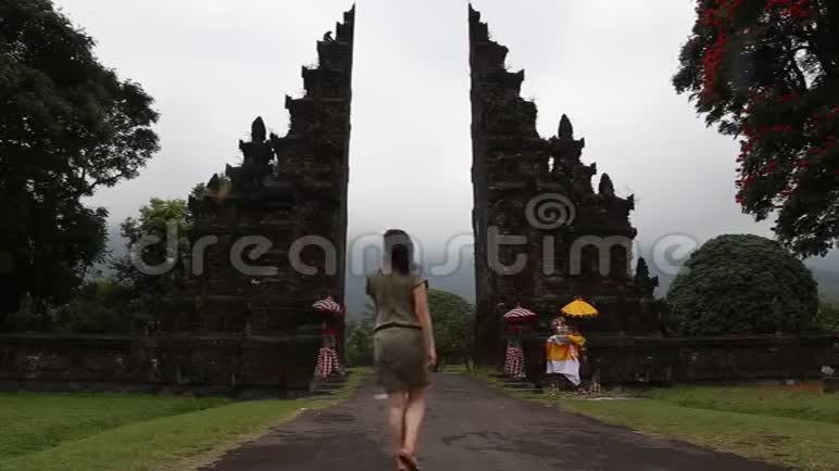 一个女人穿过巴厘岛古老的大门视频的预览图