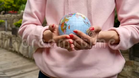 有红色指甲的女性手上面有一个小地球仪上面有用乌克兰西里尔字母命名的地理图形人类视频的预览图