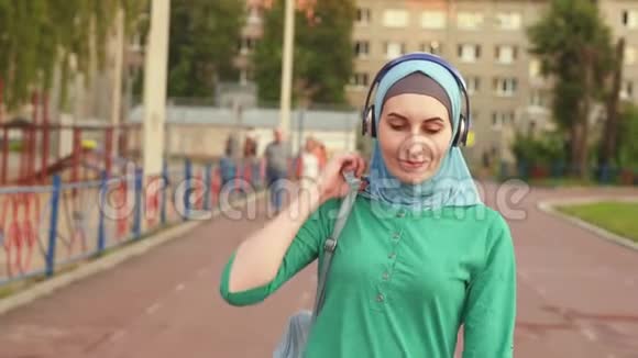 运动的年轻穆斯林女孩背着背包在运动跑道上视频的预览图