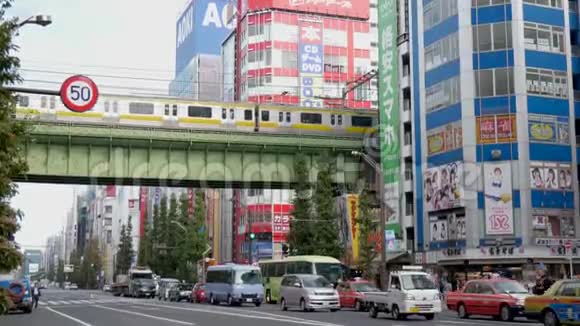 东京市中心一条繁忙的大街上一座铁路桥下的交通经过地铁火车从繁忙的道路上经过高高地起视频的预览图