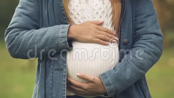 怀孕的腹部靠近母亲小心翼翼地抚摸着肚子期待着新生视频的预览图