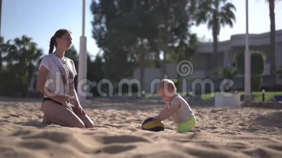 年轻的母亲在缓慢的运动中和她的孩子玩球视频的预览图