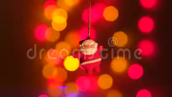 新年圣诞老人玩具挂在节日灯的背景上视频的预览图