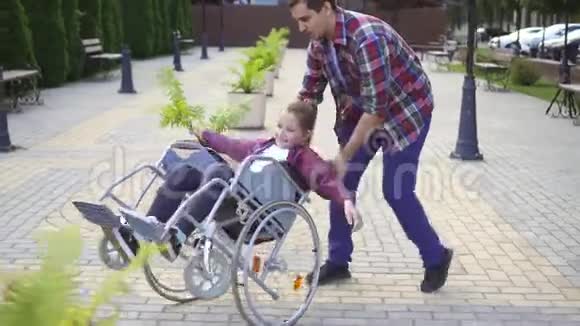 在一个夏天的公园里一个快乐的少年坐在轮椅上视频的预览图