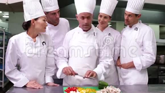 厨师团队观看主厨切菜视频的预览图