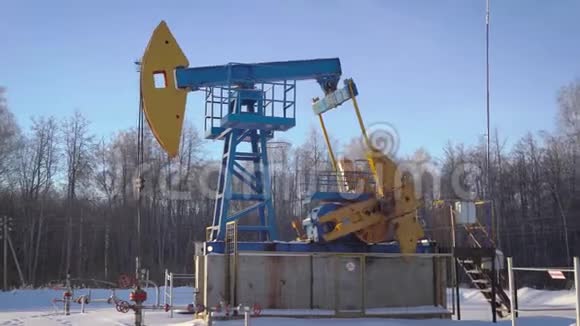 抽水站白天在冬林工作抽水机从地面抽水天然气和石油视频的预览图