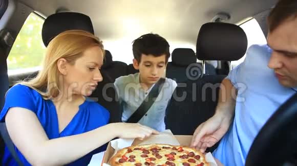 家人爸爸妈妈和儿子在车里吃披萨视频的预览图