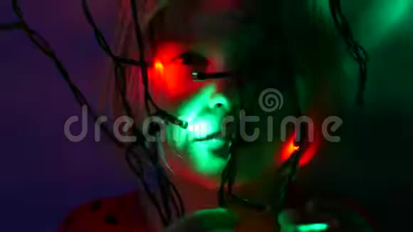 小女孩在黑暗的石榴石灯附近触摸五颜六色的球体视频的预览图