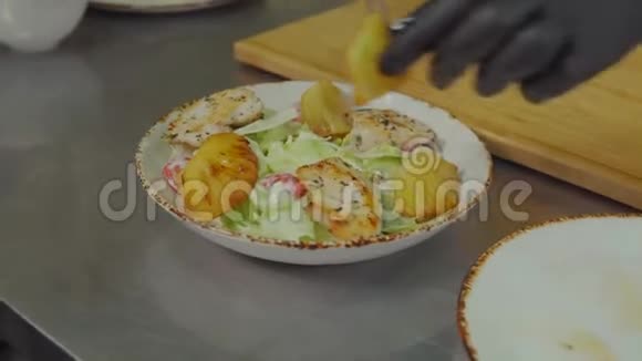 男人把油炸菠萝放在塞萨尔沙拉上不寻常的食谱特写视频的预览图