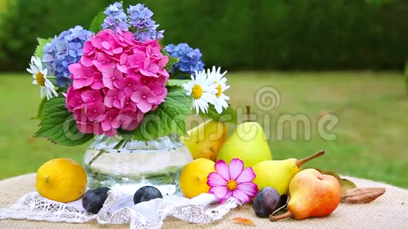 五颜六色的花束在玻璃花瓶和新鲜的混合水果视频的预览图