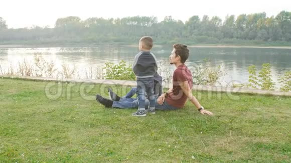 家庭和儿童的概念快乐的父亲和两个儿子在夏天公园玩得开心视频的预览图