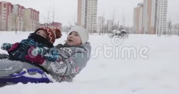 疲惫的母亲带着两个快乐的孩子拉着雪橇视频的预览图