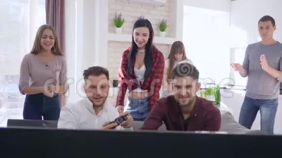 一群快乐的朋友在沙发上玩电脑游戏在现代公寓里玩得开心视频的预览图