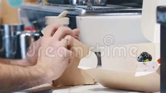 一家面包店一个男人在纸板箱里包装一个小蛋糕视频的预览图