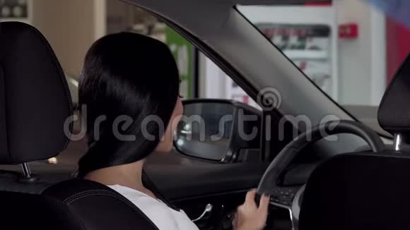 美丽的幸福女人坐在她的新车里展示着相机的汽车钥匙视频的预览图