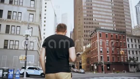 年轻英俊的商人带着文件穿过金融区在纽约过马路慢动作视频的预览图