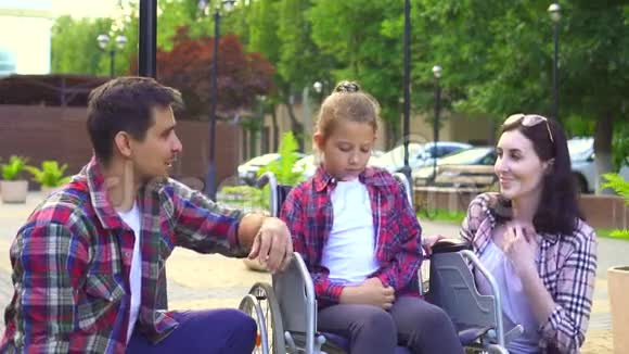 爸爸妈妈带着一个残疾的小女儿坐轮椅开心快乐视频的预览图