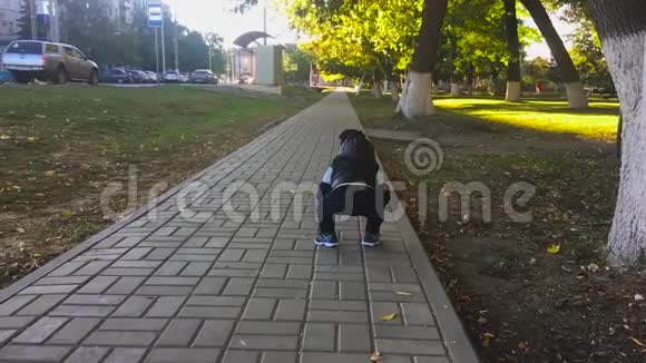 一岁的可爱男孩正在公园里迈出第一步孩子在户外迈出第一步慢动作录像视频的预览图