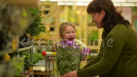 祖母和孙女正在购物中心买闻香花花壶是棕色的但花是棕色的视频的预览图