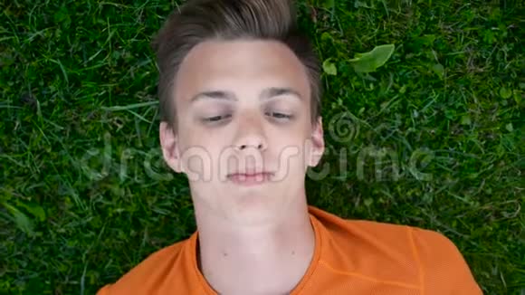 特写少年躺在草地上做梦的画像心想视频的预览图
