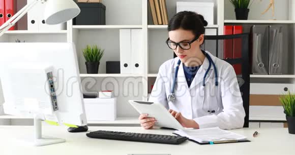 医生在办公室的白色平板电脑上打字视频的预览图
