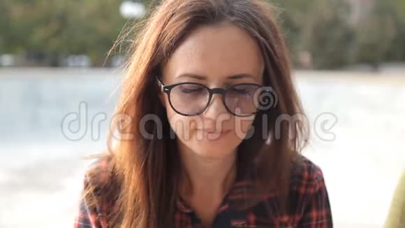 一个戴眼镜的年轻女孩尝试一个三明治一个美味的三明治欢乐公园里美味的食物视频的预览图