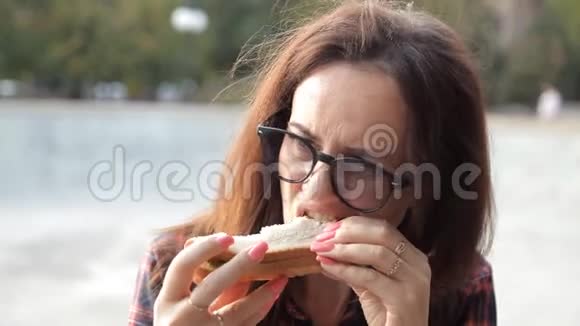 一个戴眼镜的年轻女孩尝试三明治三明治不好吃令人失望令人沮丧视频的预览图