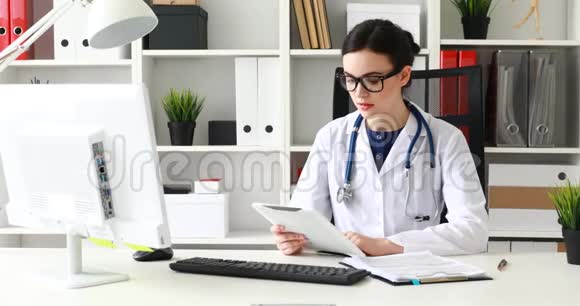 治疗师一边看着平板电脑一边在白色的办公室视频的预览图