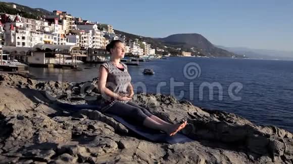 年轻健康的女性在日出时在海滩上练习瑜伽自然环境对身体的好处视频的预览图