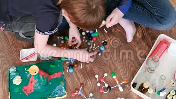 近手妈妈和儿子搭建分子模型的彩色塑料搭建套装上景视频的预览图