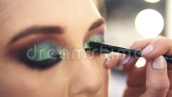 化妆大师工作侧视眼影应用的过程神秘的外表视频的预览图