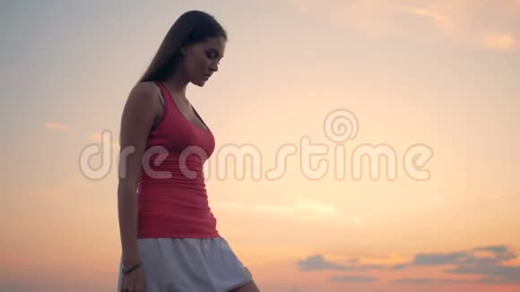 一个女孩在日落的背景下练习瑜伽视频的预览图