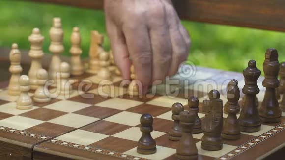 两个人在公园的长凳上下棋思考战略共同利益视频的预览图