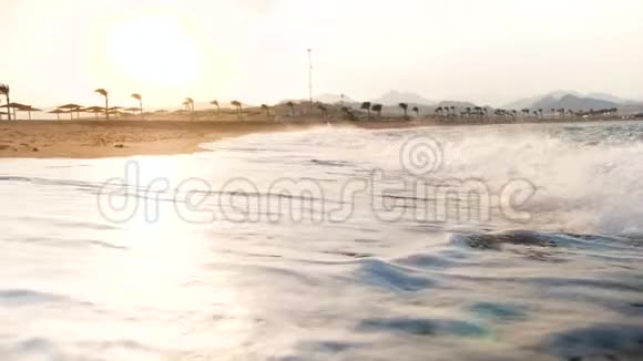 沙滩上大海浪破碎的4K慢动作视频美丽的日落在海洋上视频的预览图