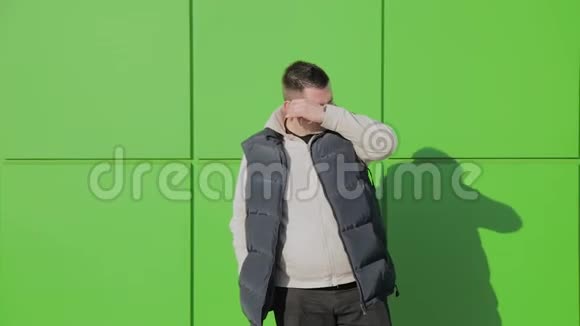 胖子在商店附近的绿色墙上摆姿势视频的预览图