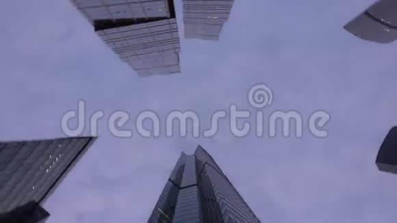 不寻常形状的现代摩天大楼由玻璃制成底部向上看旋转视频的预览图
