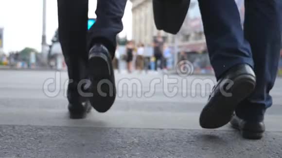 两个商人在市中心过马路在大城市走人行横道的男同事的腿青年视频的预览图