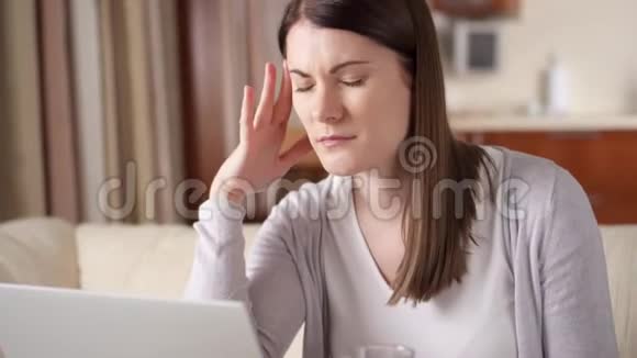 工作过度头痛的女人在家吃药生病生病头痛视频的预览图