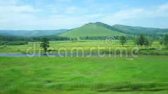 从火车窗口观看带有山丘和树木的景观视频的预览图