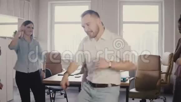 年轻的高加索男性高管在有趣的休闲办公室聚会上跳滑稽的胜利舞庆祝商业成就4K视频的预览图