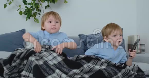 两个孩子在电视上看一个令人兴奋的电视节目两个兄弟在看电视视频的预览图