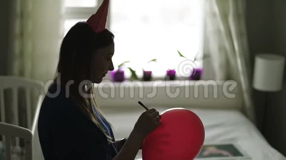 一位戴着节日礼帽的年轻女子向一个红色气球表示祝贺视频的预览图