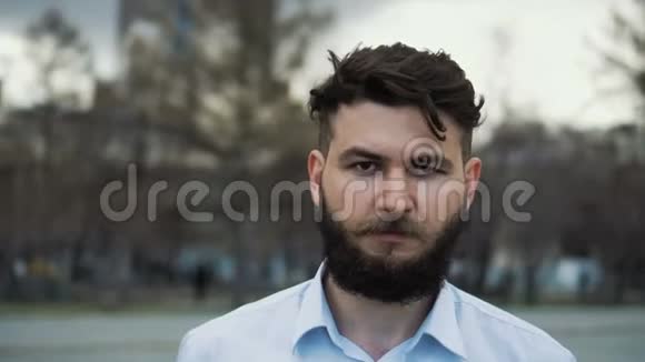 一个留着胡须发型漂亮的男人在城市的一条街上特写4k视频的预览图