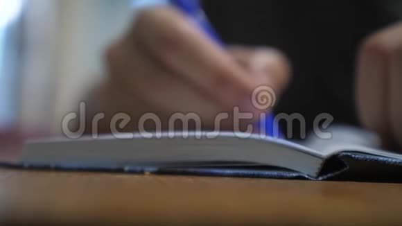 人在笔记本上写字男人用记事本写生活方式概念商业教育1男人在房间里做笔记视频的预览图