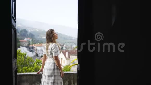 村中山峦间别墅阳台上的女士视频的预览图